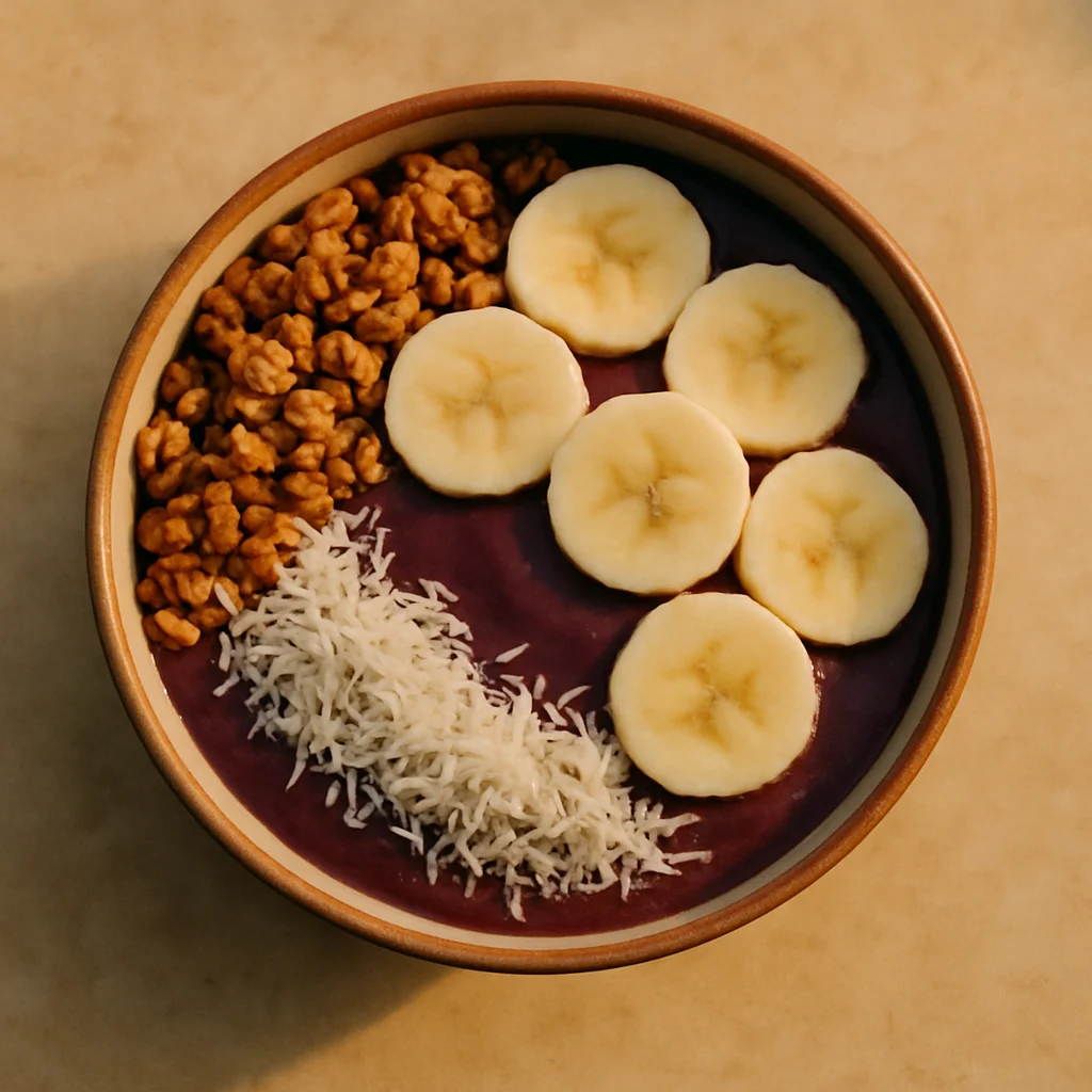 An overhead view of a delicious açaí bowl topped with bananas, granola, and coconut flakes.