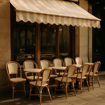 Jigsaw puzzle: An empty outdoor cafe with wicker chairs and small tables under a striped awning.