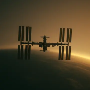 Jigsaw puzzle: The International Space Station is silhouetted against Earth's golden atmospheric glow at sunrise.